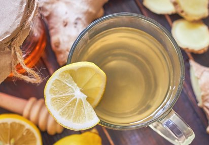 A photograph of a hot cup of tea with a lemon wedge along the rim of the cup. | Nutters A photograph of a hot cup of tea with a lemon wedge along the rim of the cup. | Nutters